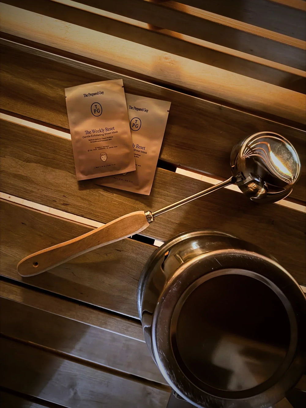 An image of sheet mask sachets, a bucket and a ladle in sauna