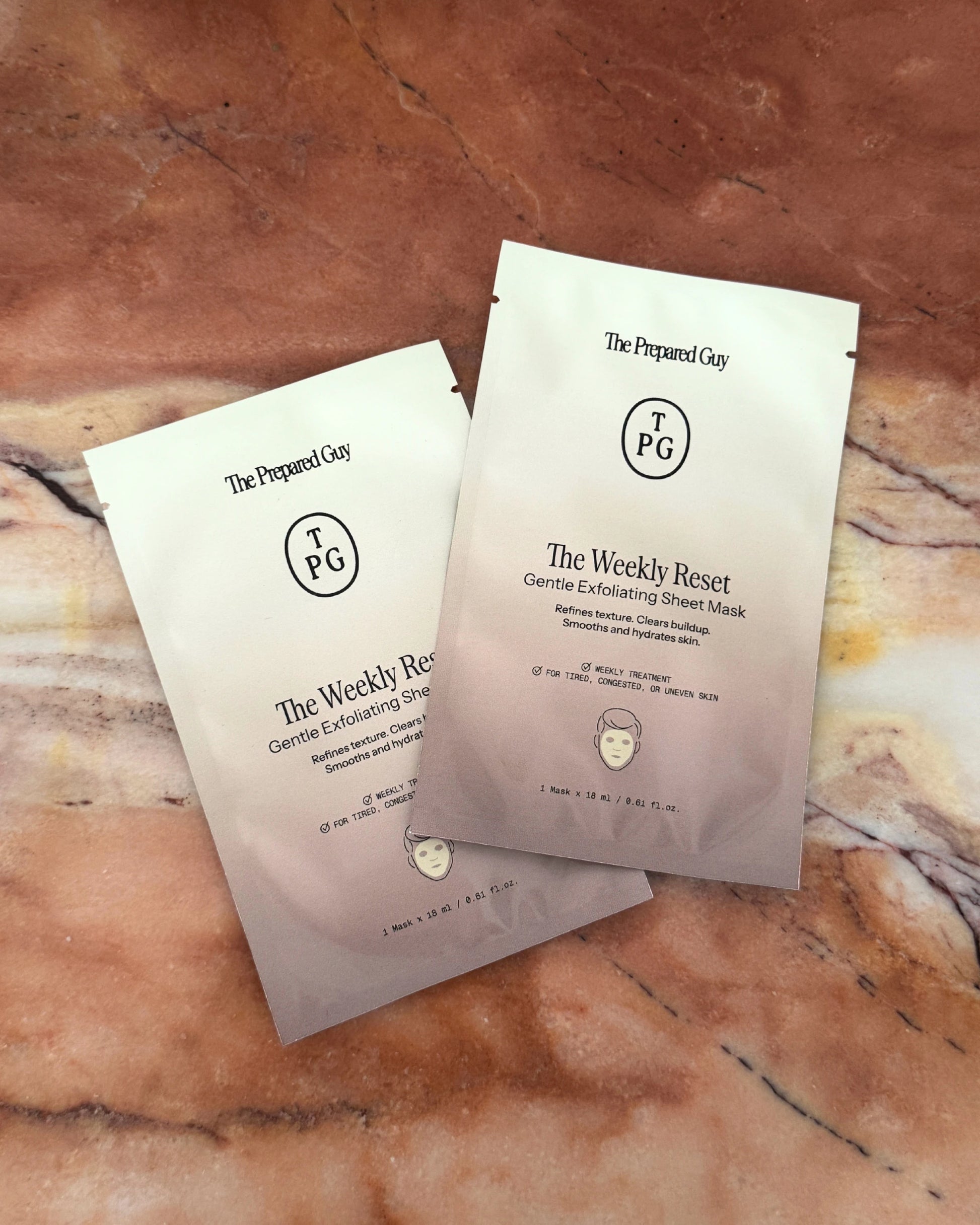 Two sheet mask packages on brown marble