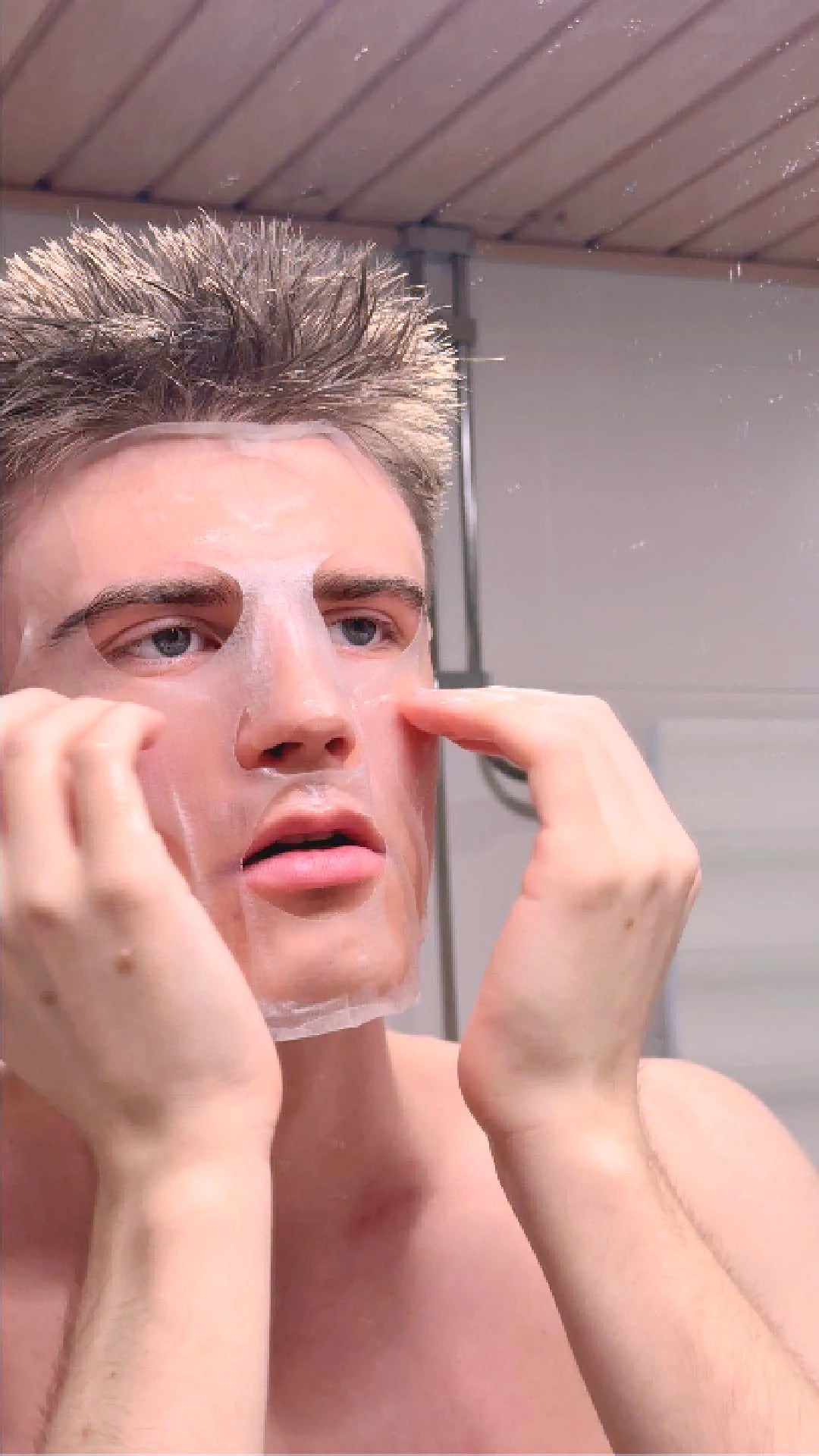 Man applying a sheet mask on his face for skincare